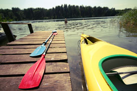 A man performing white water kayaking. He is fighting rough waters.